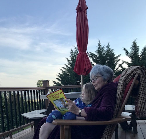 Reading as the sun comes up over the deck. Jammies and robe.
